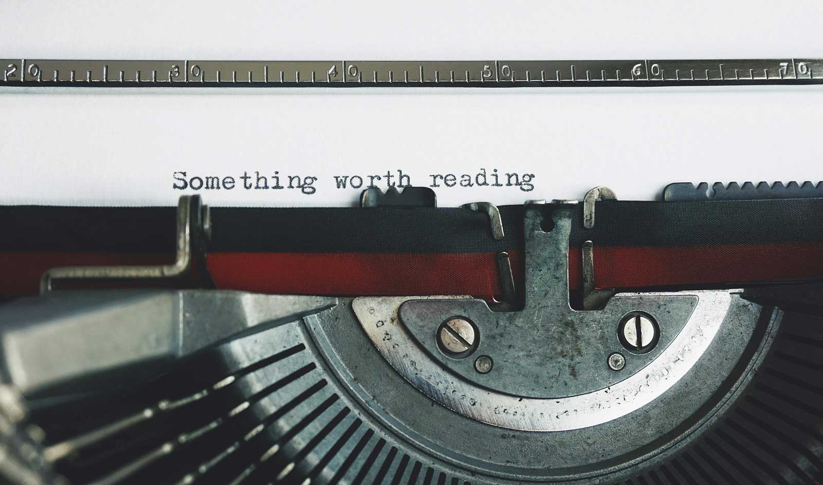 Old typewriter typing words "Something worth reading"